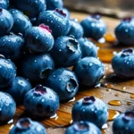 Fresh wet blueberries scattered on a wooden table